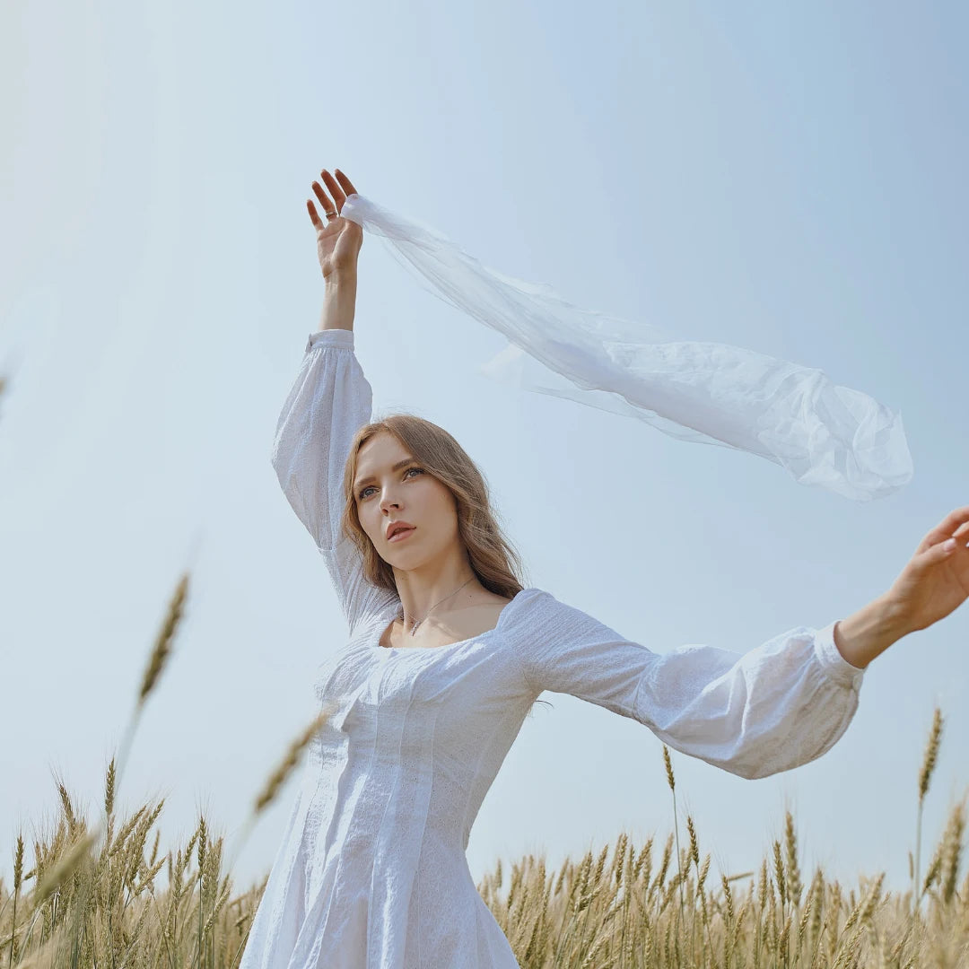 Woman Holding Scarf in Field